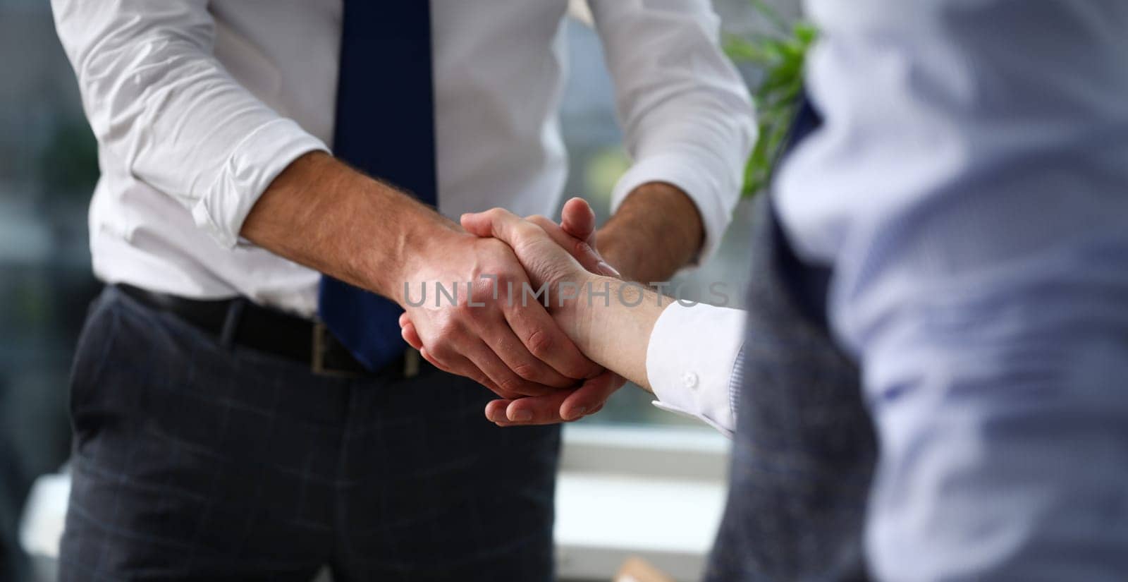 Man in suit and tie give hand as hello in office closeup by kuprevich