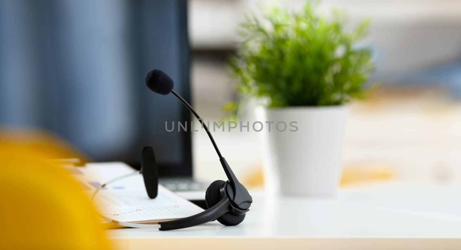 Empty remote office workplace with laptop pc and headset closeup. Receptionist or secretary of contact data center desktop keyboard device desk table ip telephony or callcenter voice message system