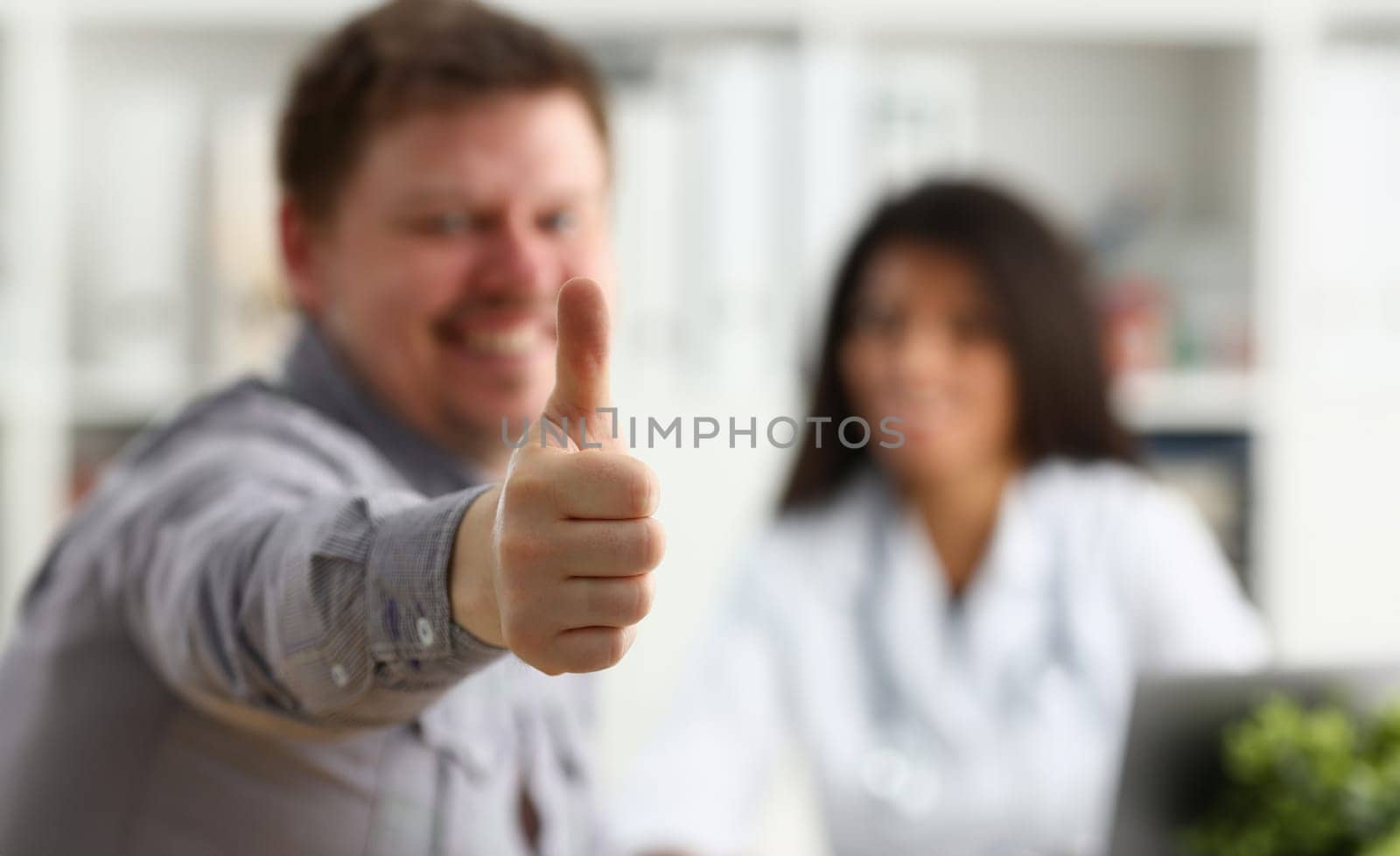 Man showing ok sign with thumb up at physician office portrait. High level work confident satisfied male do like visit to clinic best occupation emergency help teamwork concept