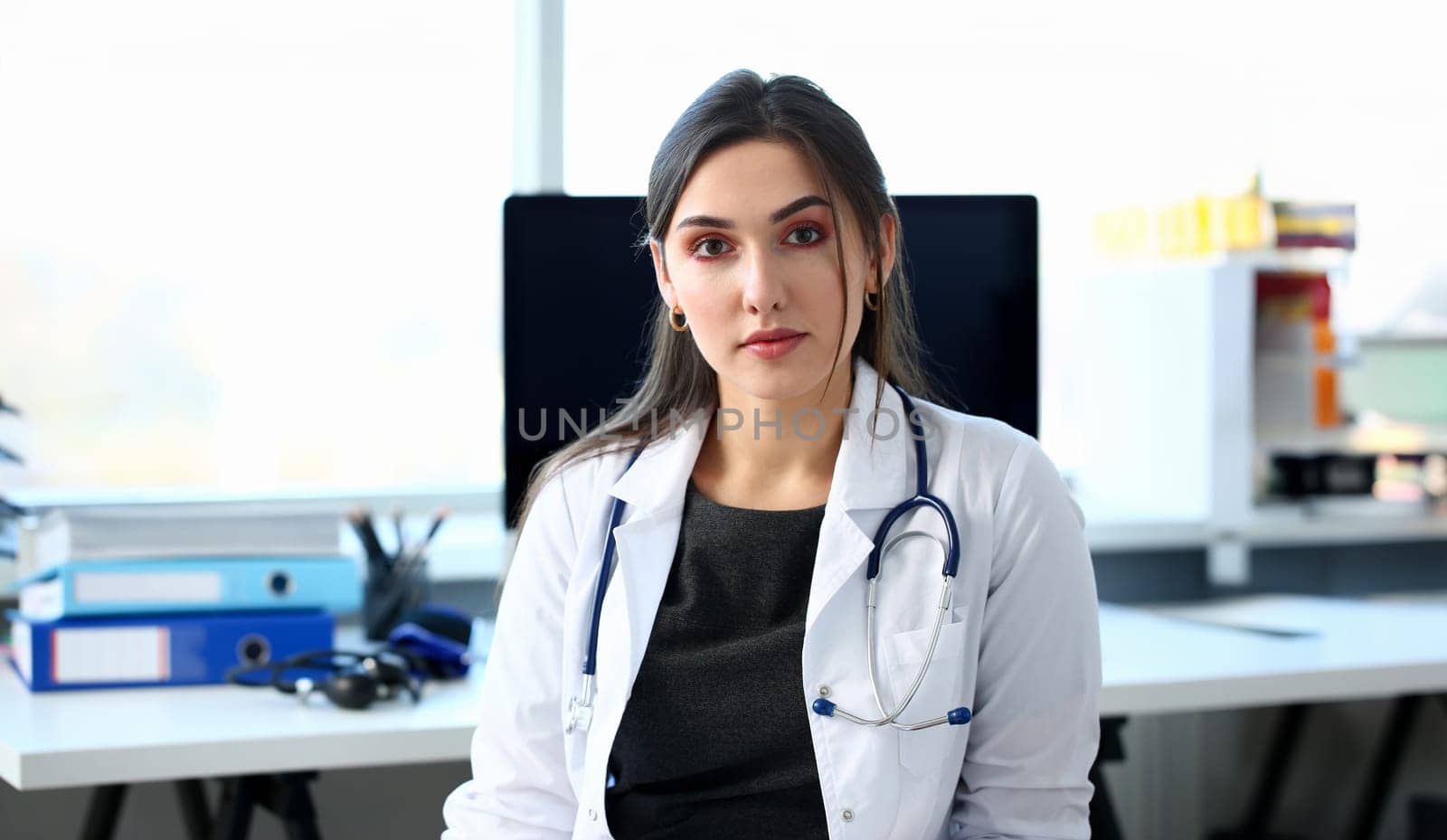 Beautiful smiling female doctor at workplace portrait by kuprevich