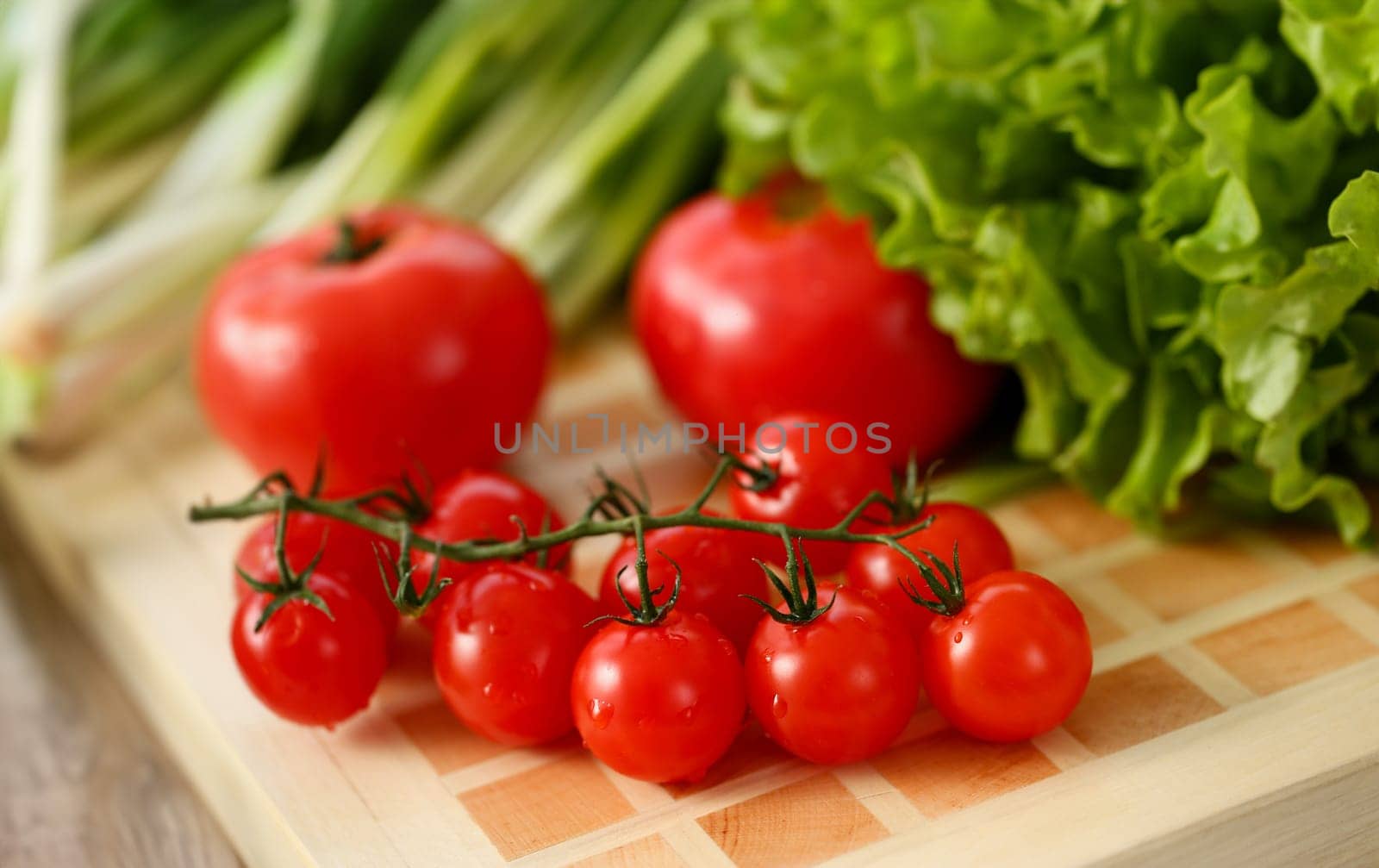 Cherry tomatoes lie on a cutting board by kuprevich