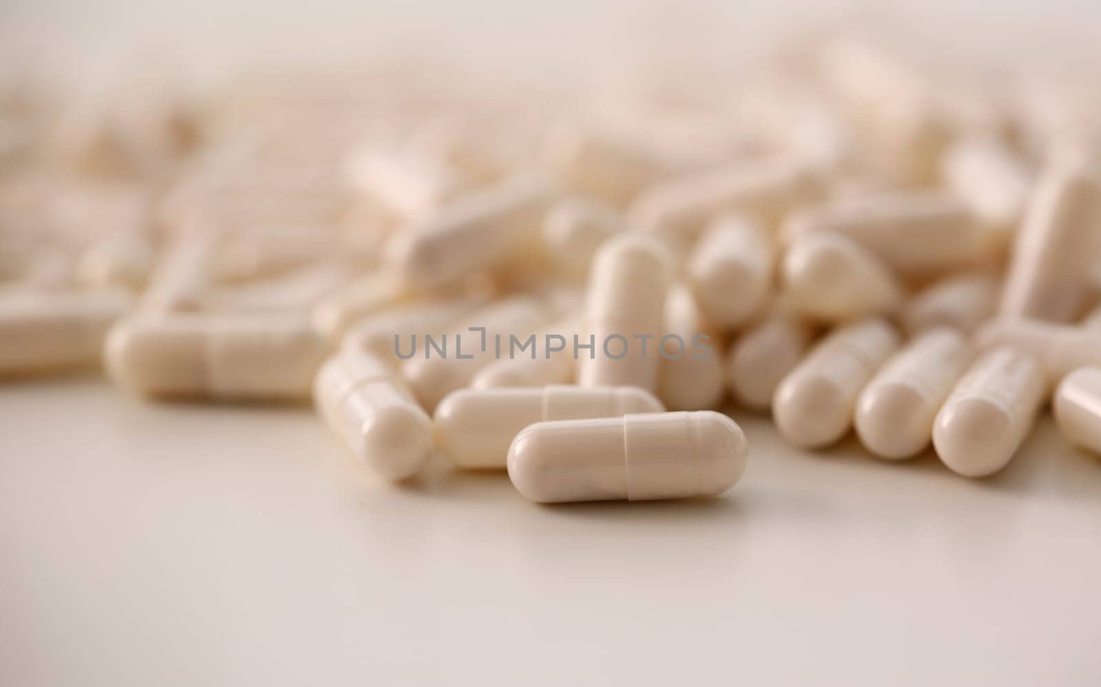 Tablets scattered white color on table of pharmaceutical laboratory pill for prescription and treatment various diseases chemistry background closeup