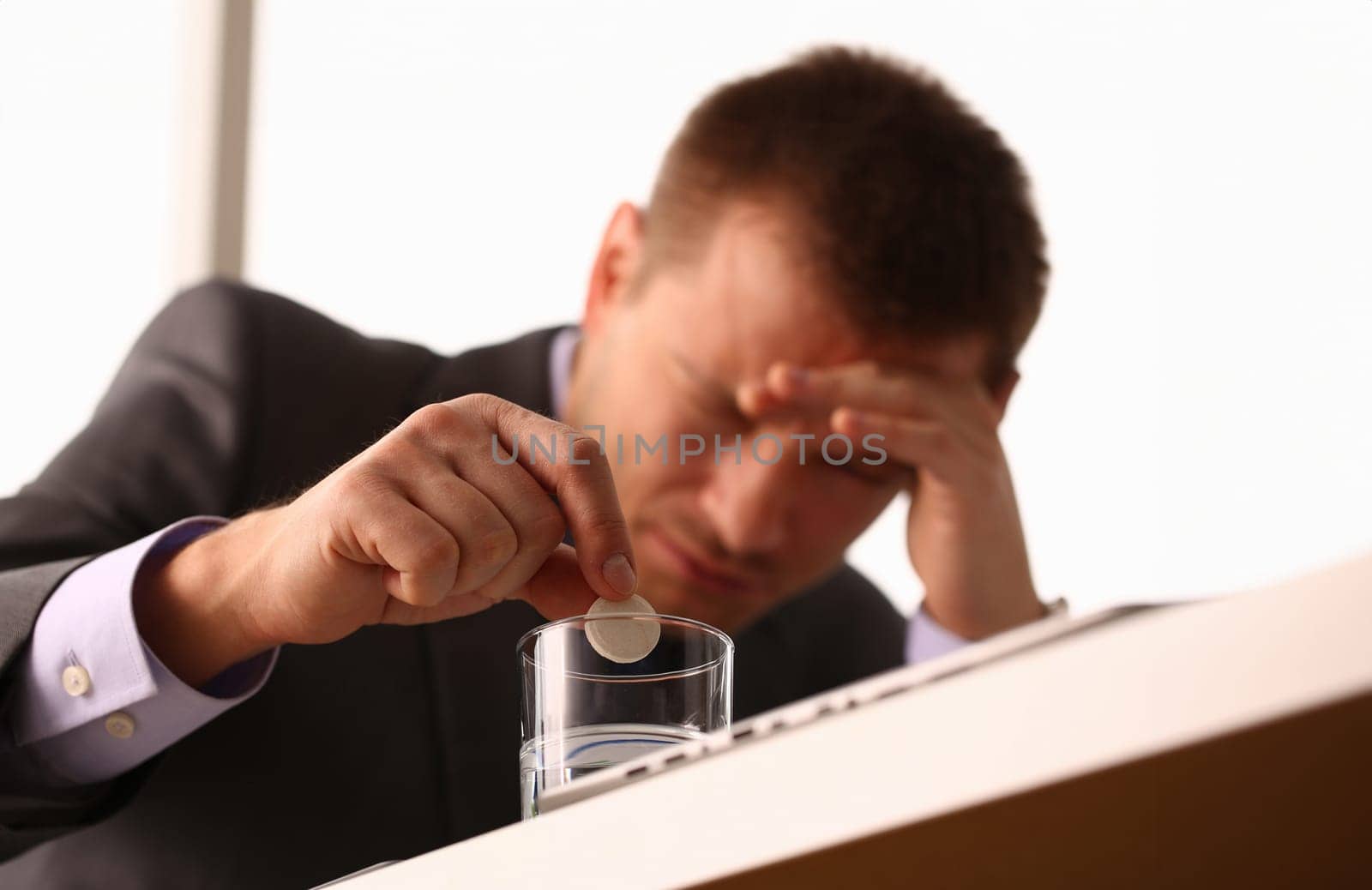 Adult male businessman hold tablet on glass water. On January 1 after celebrating the new year came to work while intoxicated closeup concept