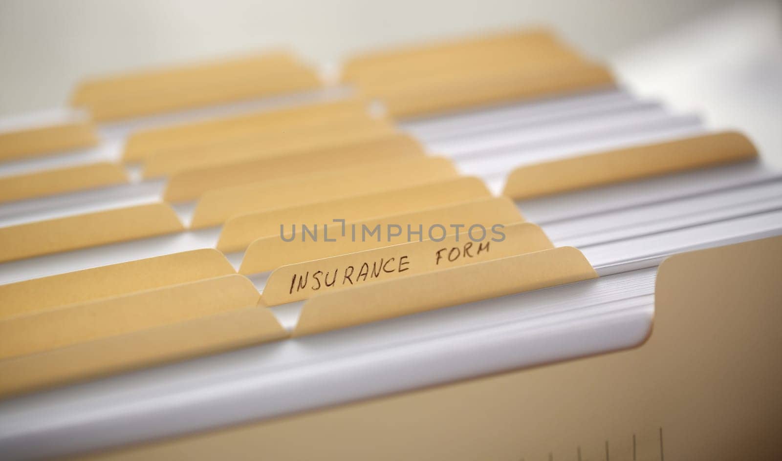 Yellow folders with labels and paper in a row in the insurance file closeup