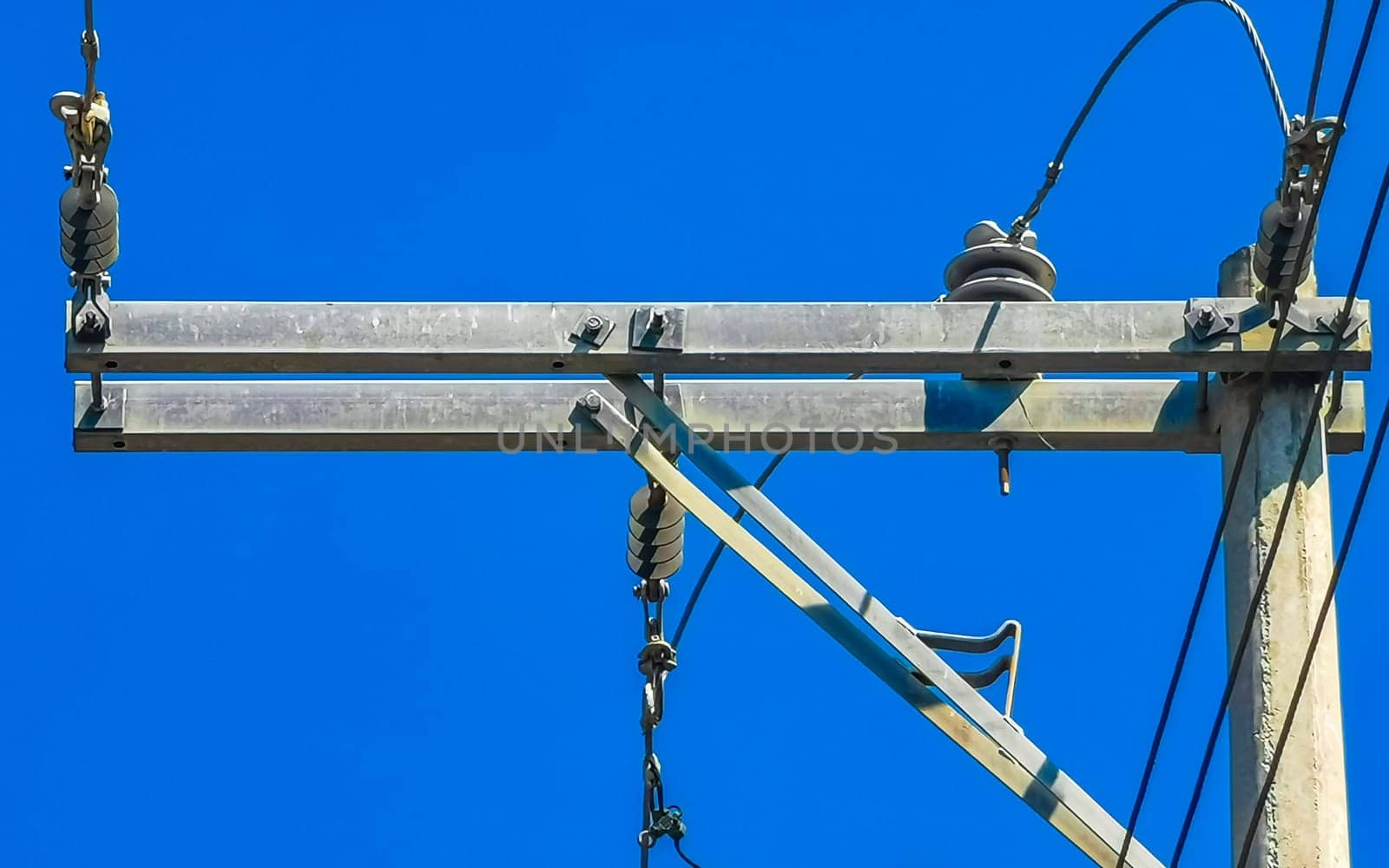 Power pole cable box with blue sky in Mexico. by Arkadij