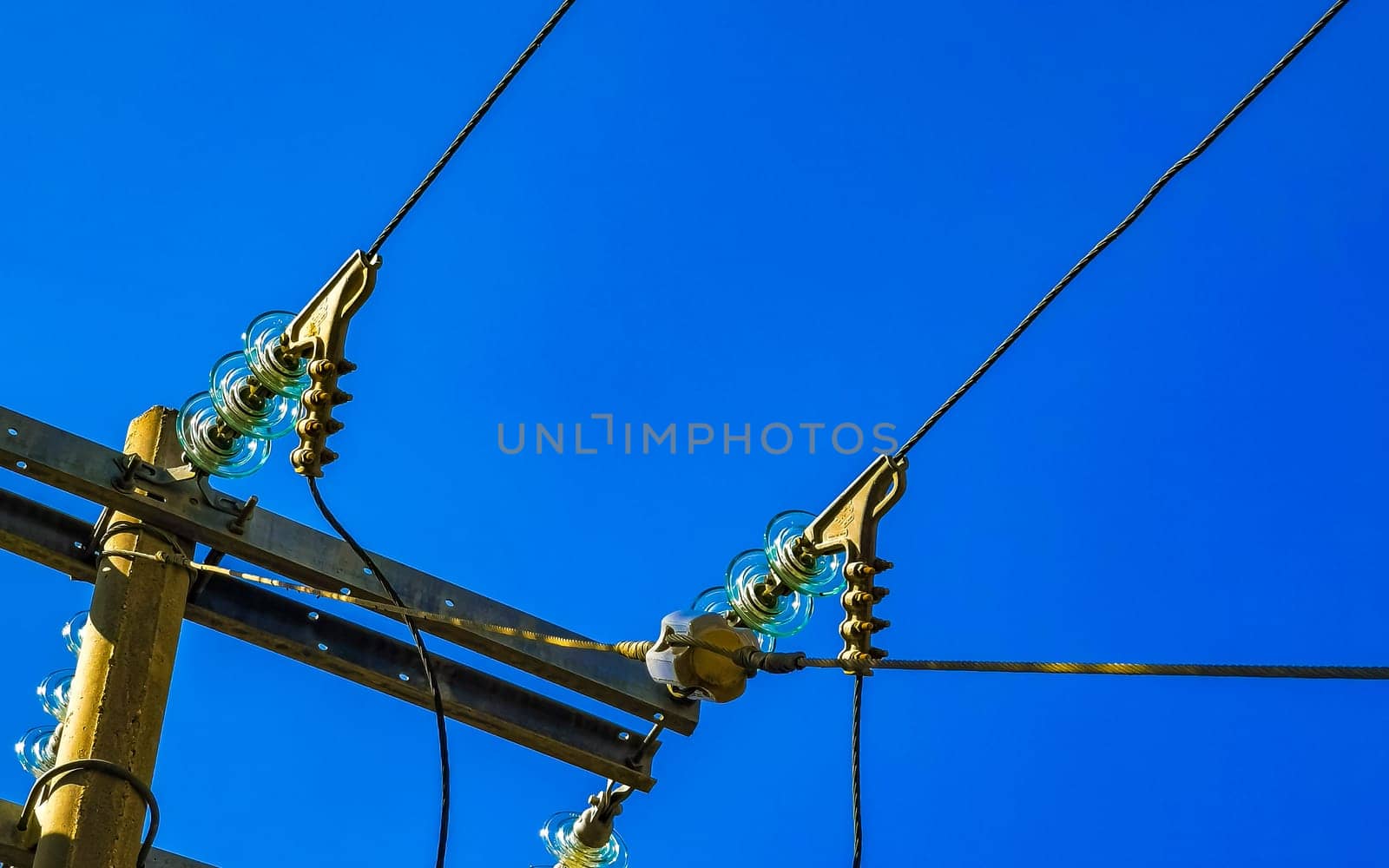 Power pole cable box with blue sky in Mexico. by Arkadij