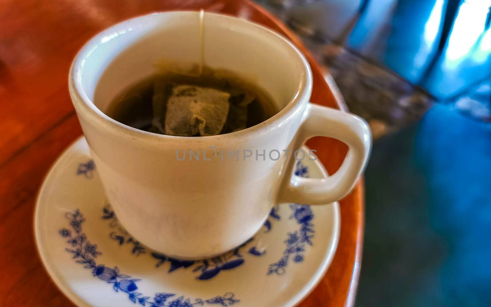 White cup of tea with tea bag on wooden table in Zicatela Puerto Escondido Oaxaca Mexico.