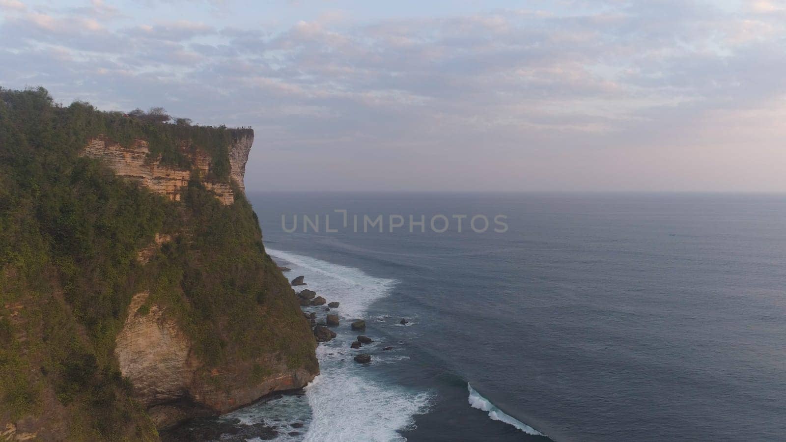 aerial view rocky ocean coastline at sunset. seascape waves break on rocky shore travel concept.
