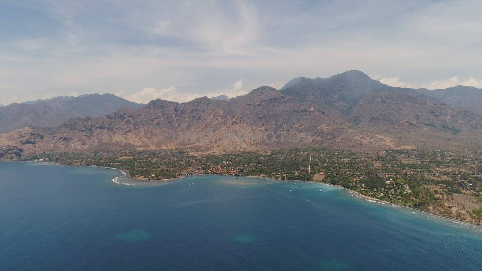 aerial tropical landscape town by sea, mountains, beach, boats on surface water. Bali,Indonesia, travel concept