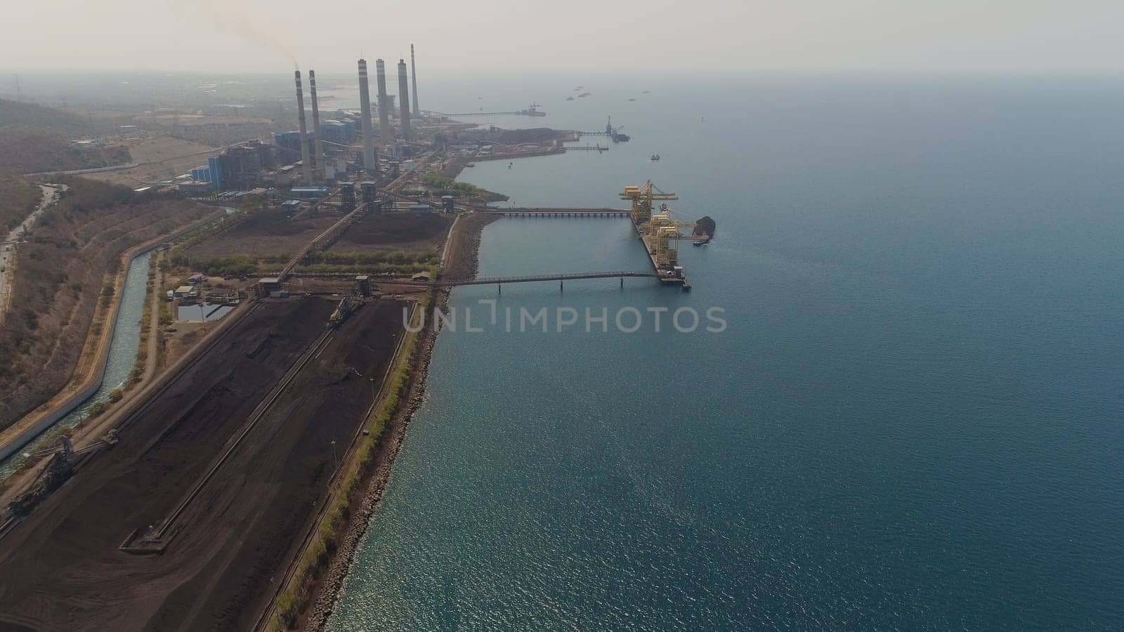 power station by sea with smoking pipes, paiton java, indonesia. aerial view power plant in asia.