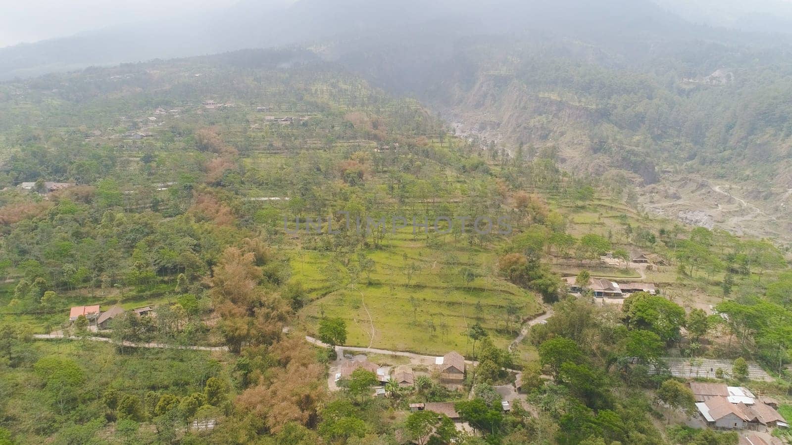 mountain landscape slopes mountains covered with green tropical forest. Jawa, Indonesia. aerial view mountain forest with large trees and green grass.