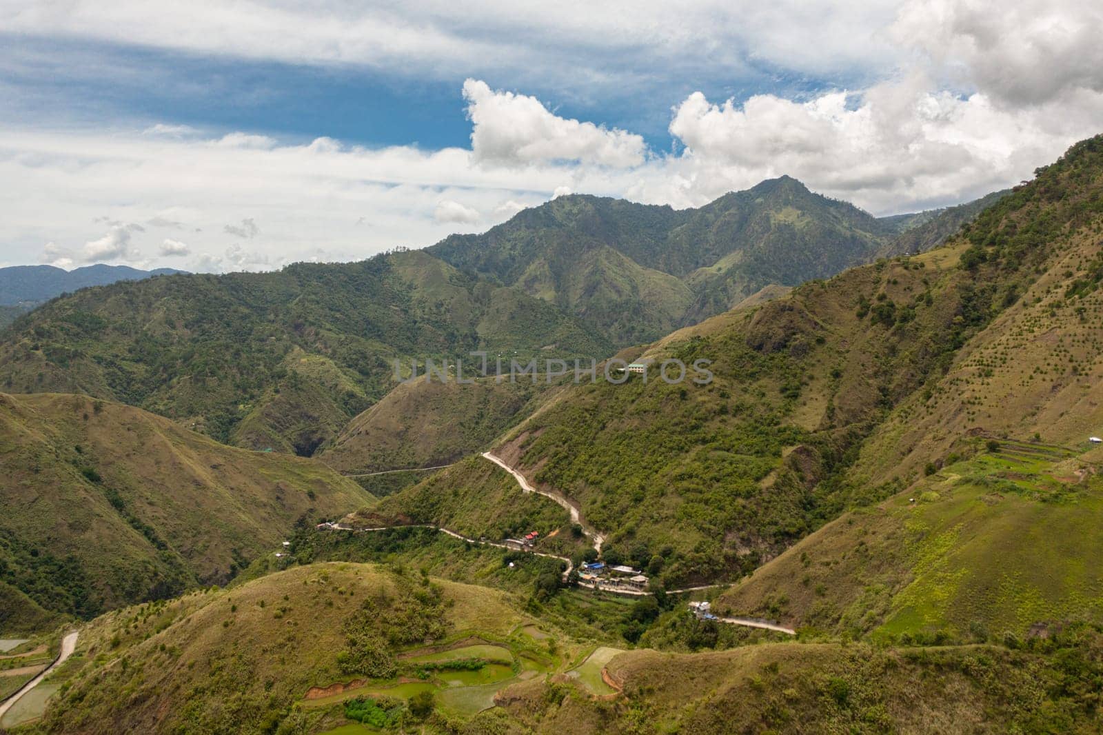 Mountains covered rainforest, trees and blue sky with clouds. Philippines.