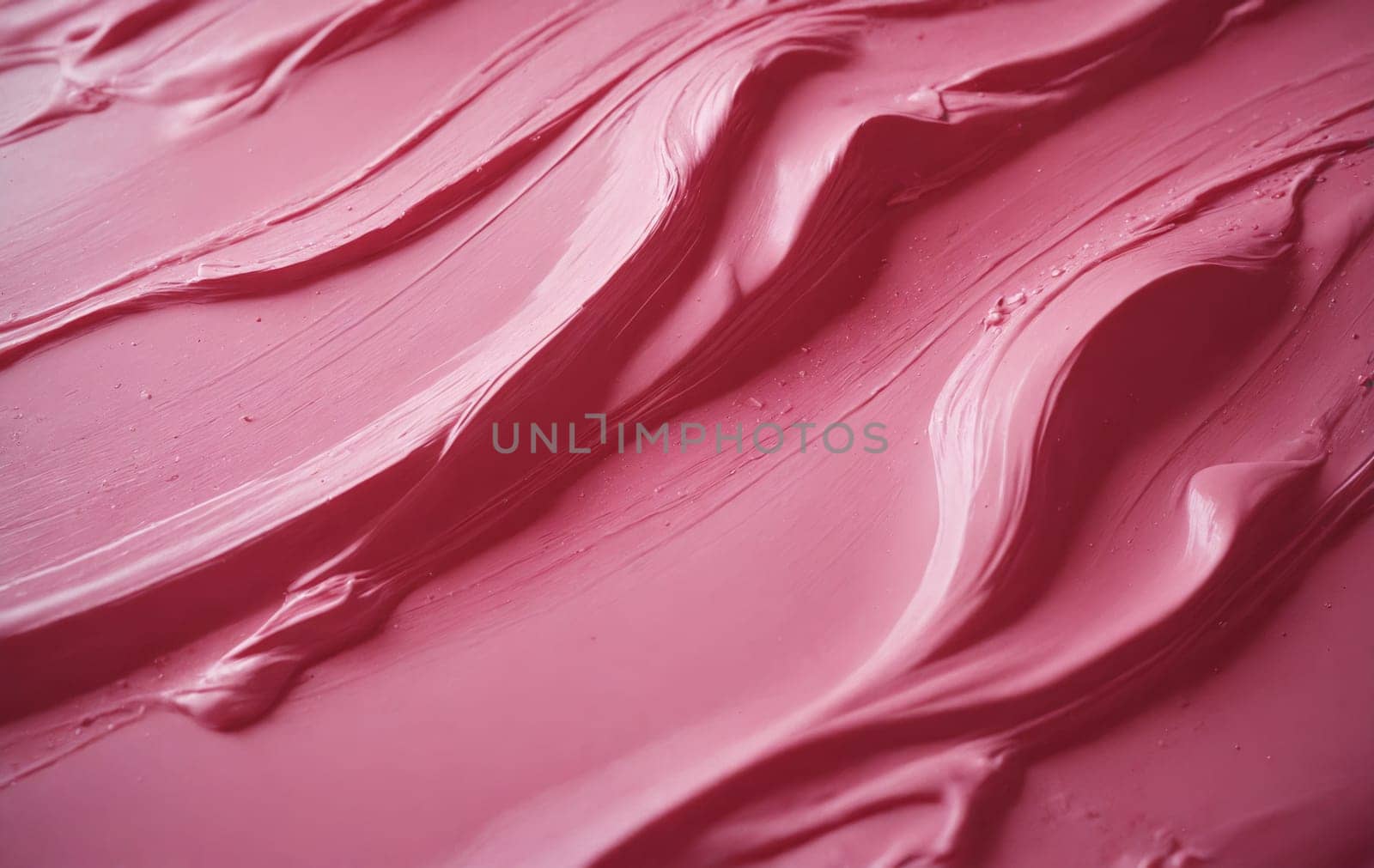 A closeup of a vibrant pink lipstick texture, showcasing a range of shades like petal, violet, magenta, and peach. The liquid formula creates a beautiful pattern with hints of carmine