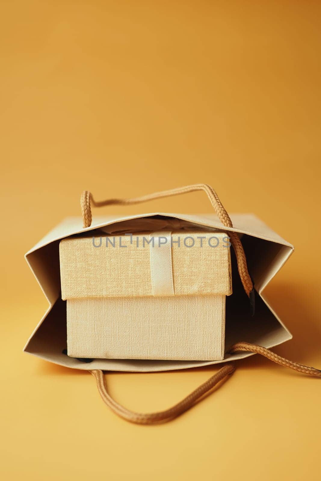 Gift or present box with paper packet on orange color background