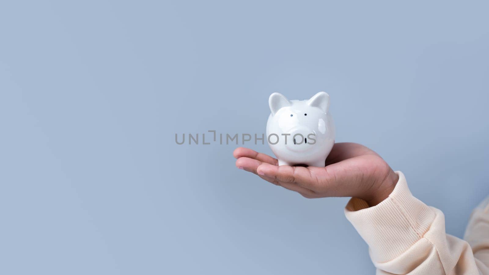 A boy holding piggy bank. Learning financial responsibility and projecting savings. savings concept. investment concept. by Unimages2527
