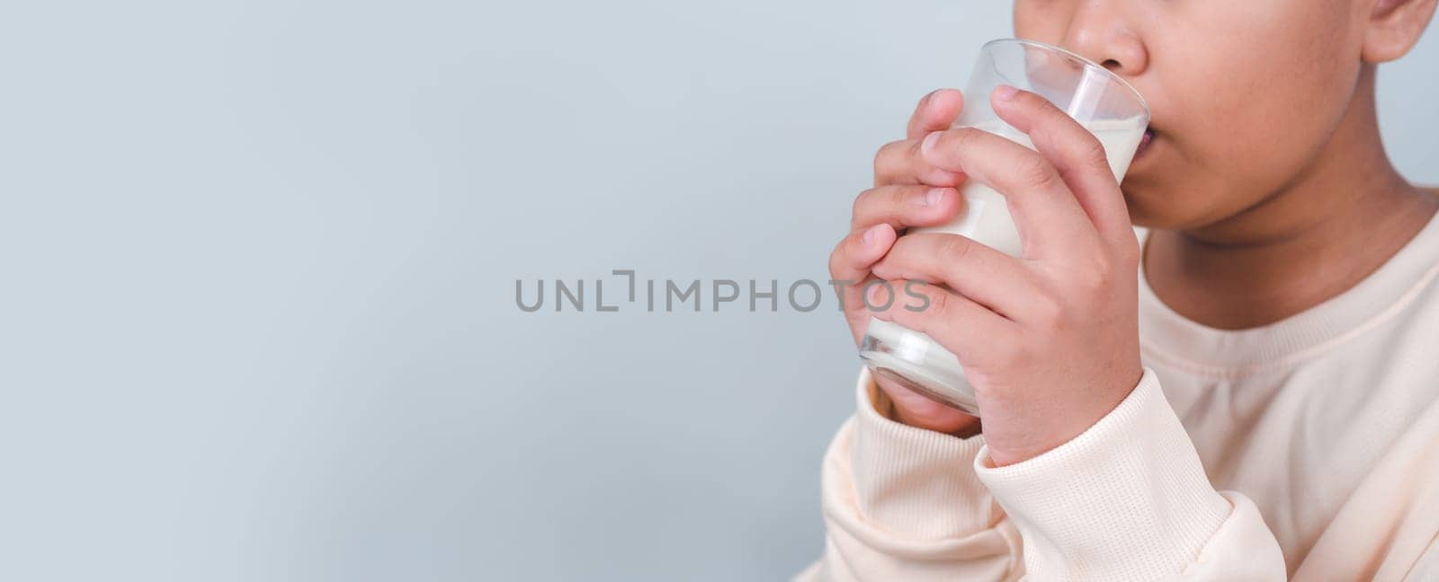 Concept of happy good nutrition, Portrait of a little young handsome kid boy in cream color shirt, Hold drinking milk box mockup, Isolated on white background. by Unimages2527
