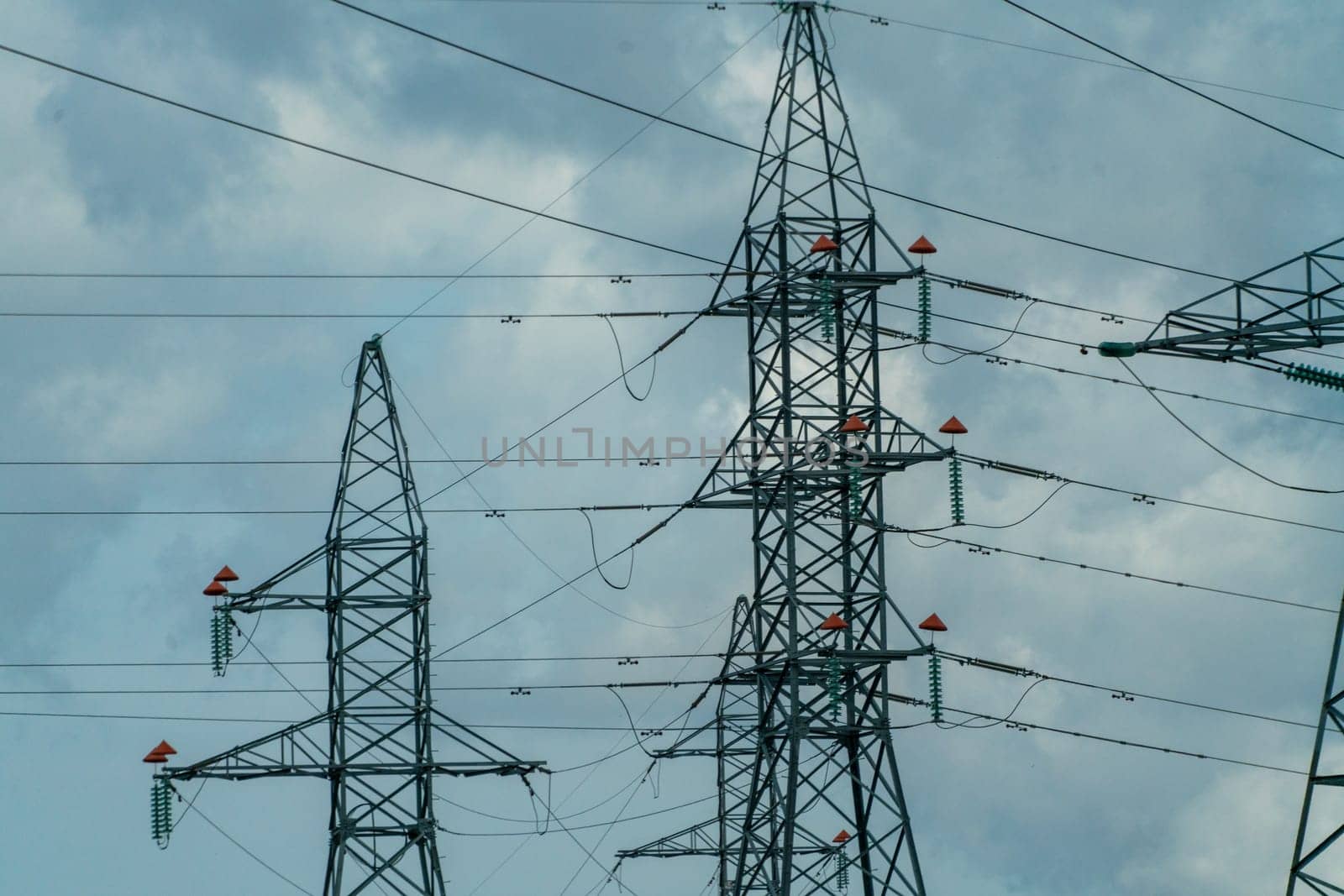 High voltage towers with sky background. Power line support with wires for electricity transmission. High voltage grid tower with wire cable at distribution station. Energy industry, energy saving.