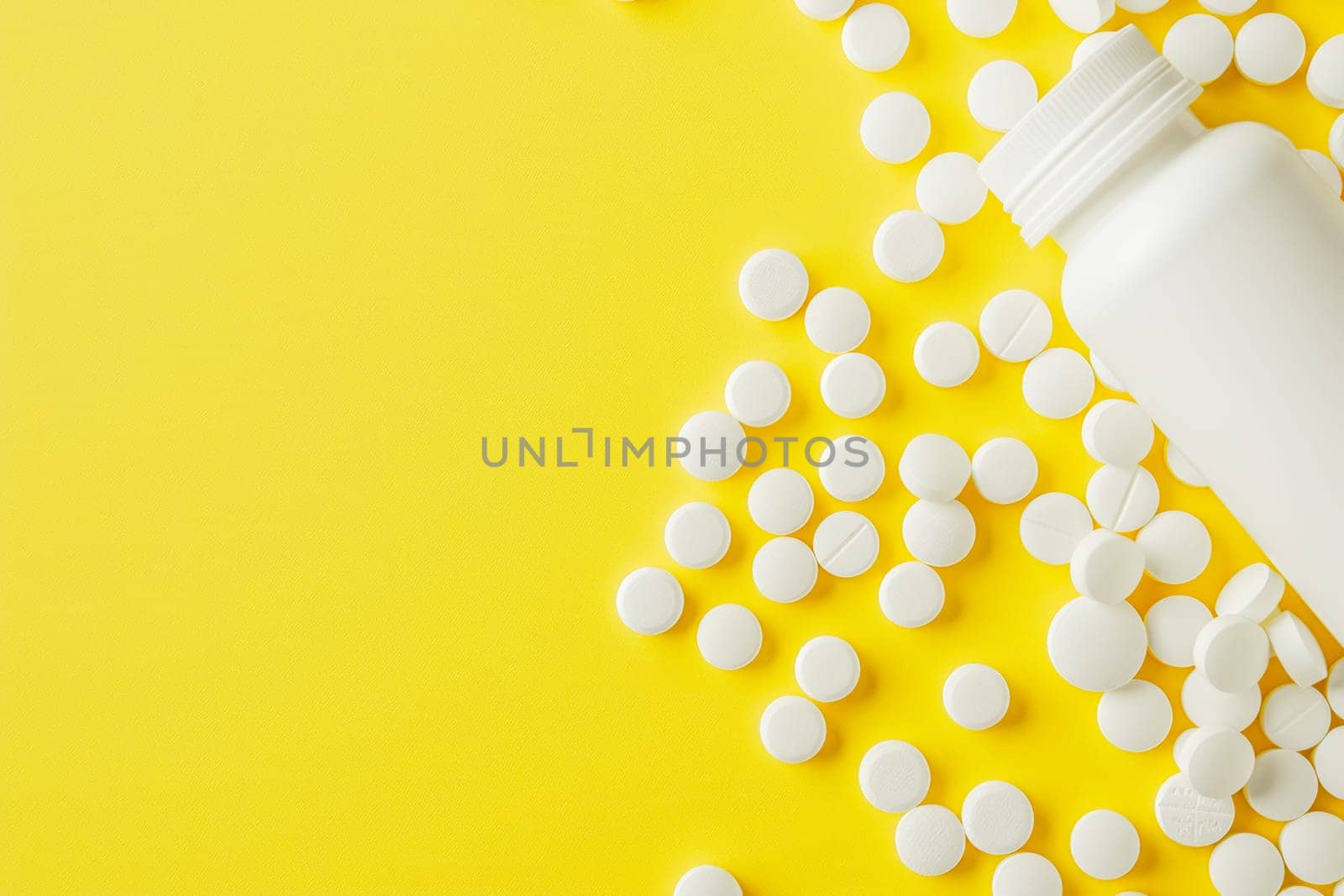 White medicine pills spilled from plastic pill bottle, on yellow background. Medicine creative concepts. Flat lay top view, copy space.