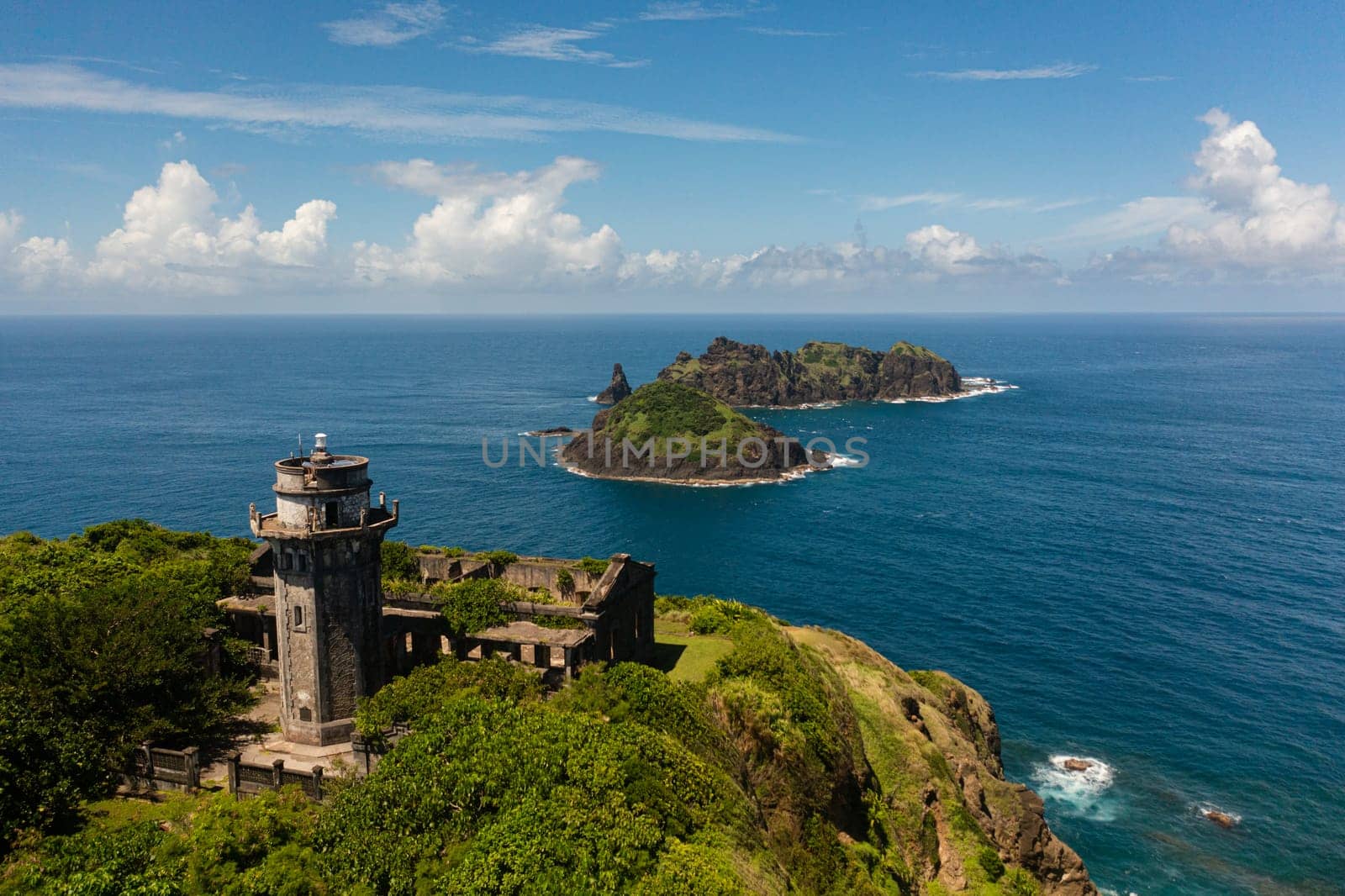 Aerial view of Lighthouse and tropical islands on the background of the blue ocean. Cape Engano. Palaui Island. Santa Ana Philippines.