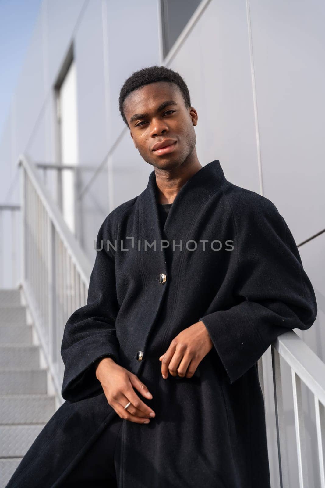 African model posing with black clothes railing on stairs by Huizi