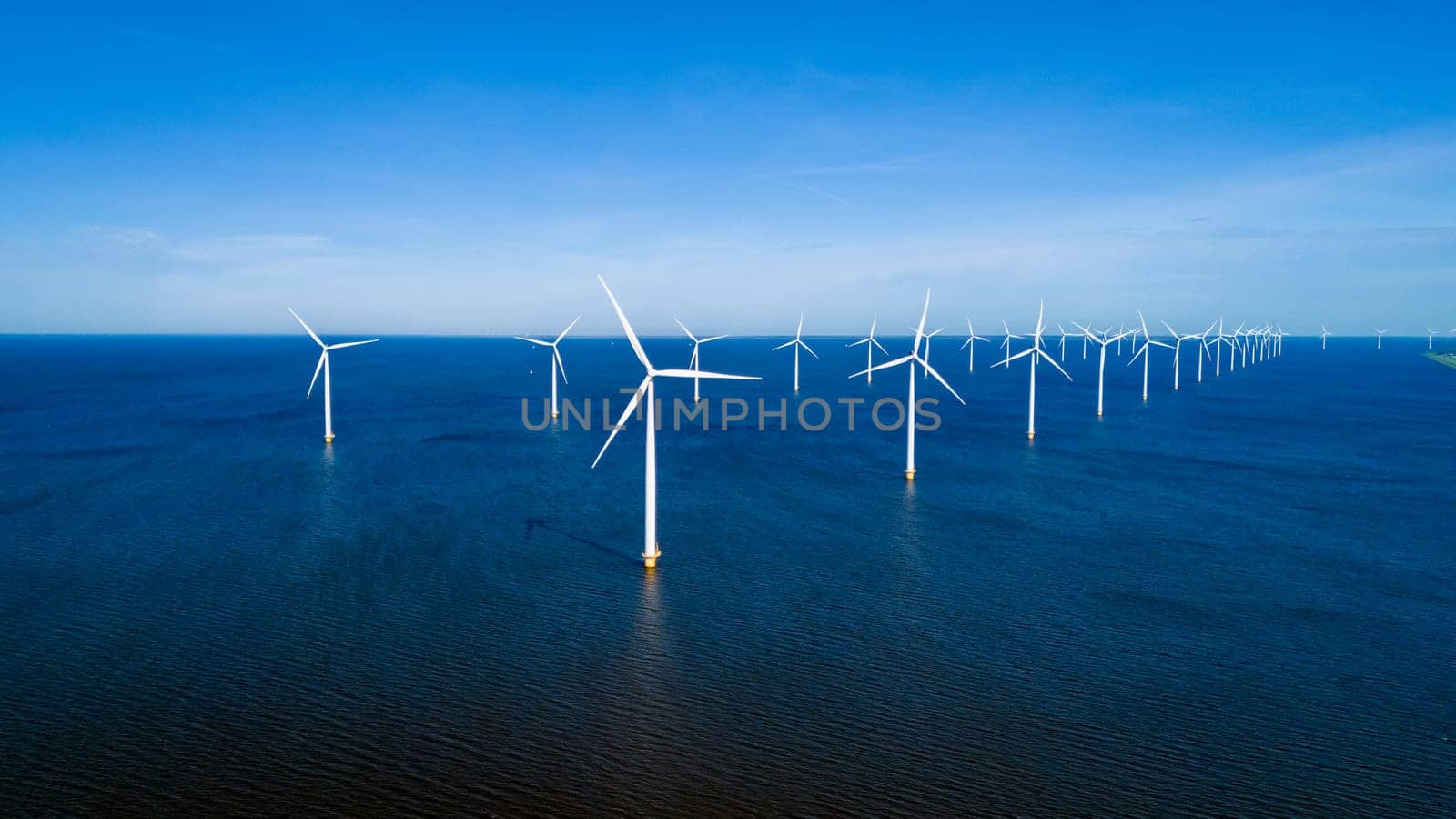 wind turbines stand in the ocean drone aerial view of windmill turbines green energy in the ocean by fokkebok