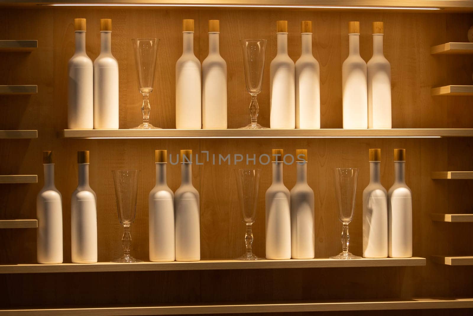 shelf with bottles and glasses in beautiful lighting by drakuliren