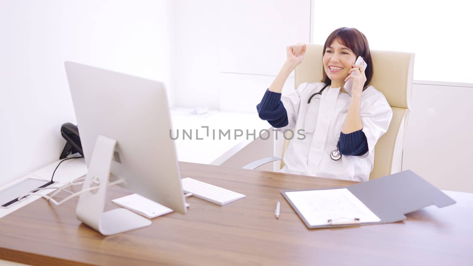 Female doctor calling a patient to communicate the good results of a medical test