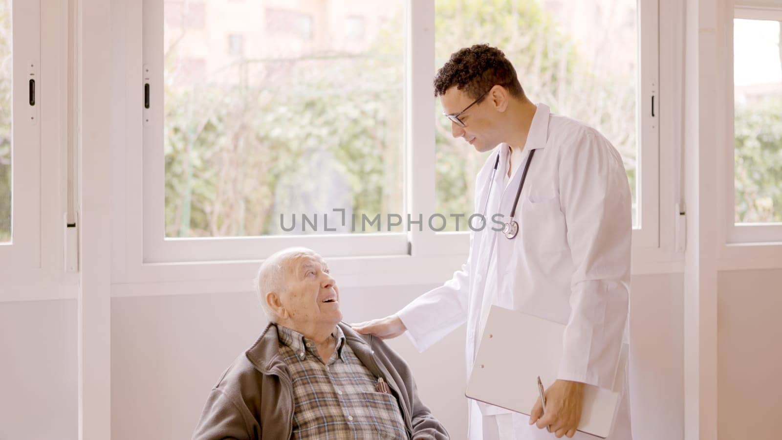 Male doctor standing talking with a senior man in a medical checking routine the nursing home