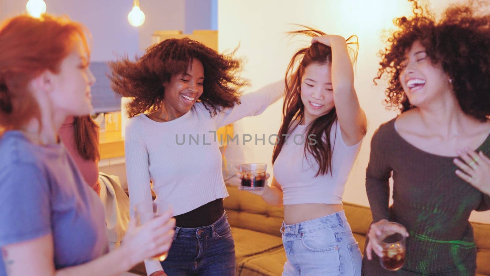 View of multi-ethnic women dancing happily in a night party at home