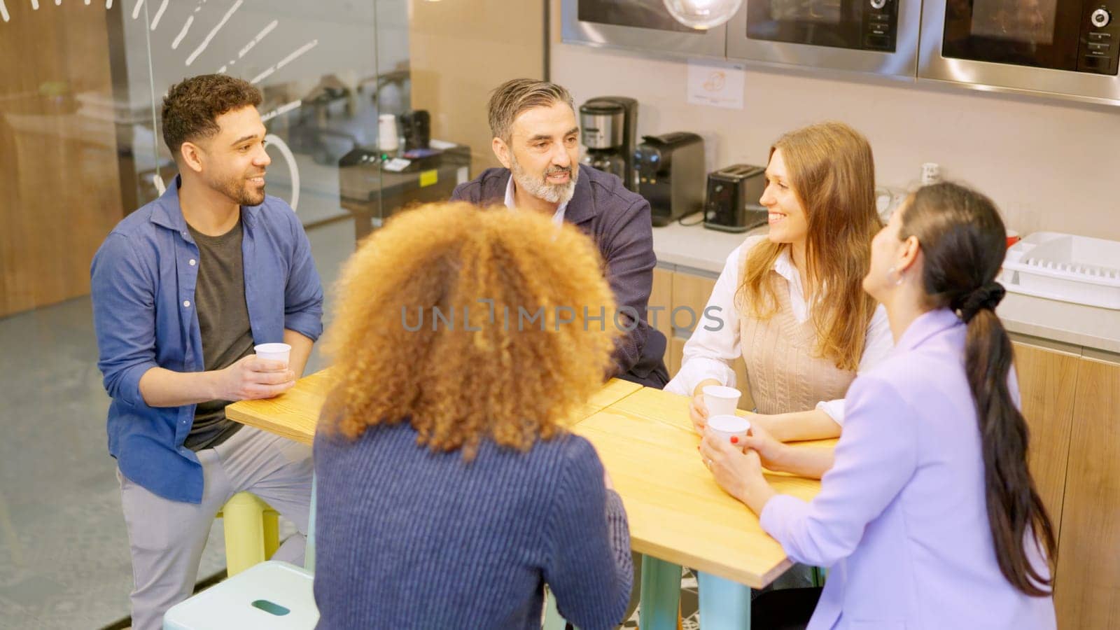 Group of workers chatting during coffee break in a coworking