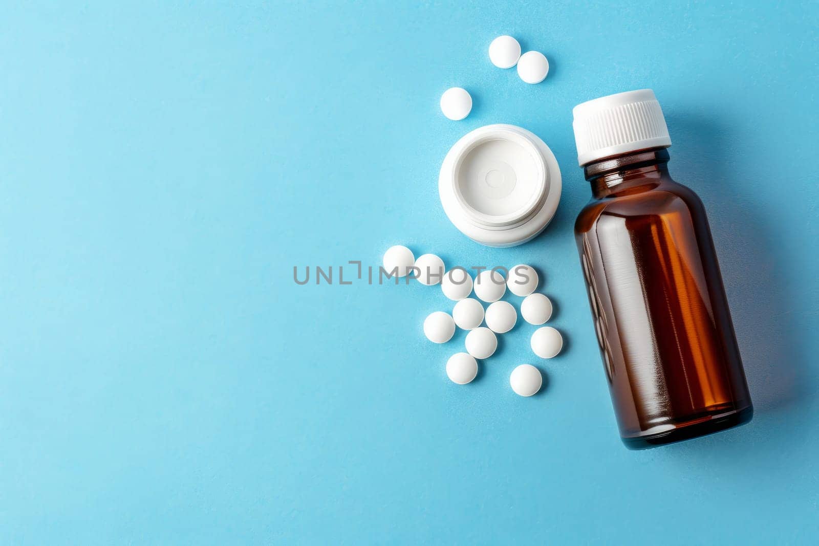 Medicine pills spilled from plastic pill bottle, on blue background. Medicine creative concepts. Flat lay top view, copy space.