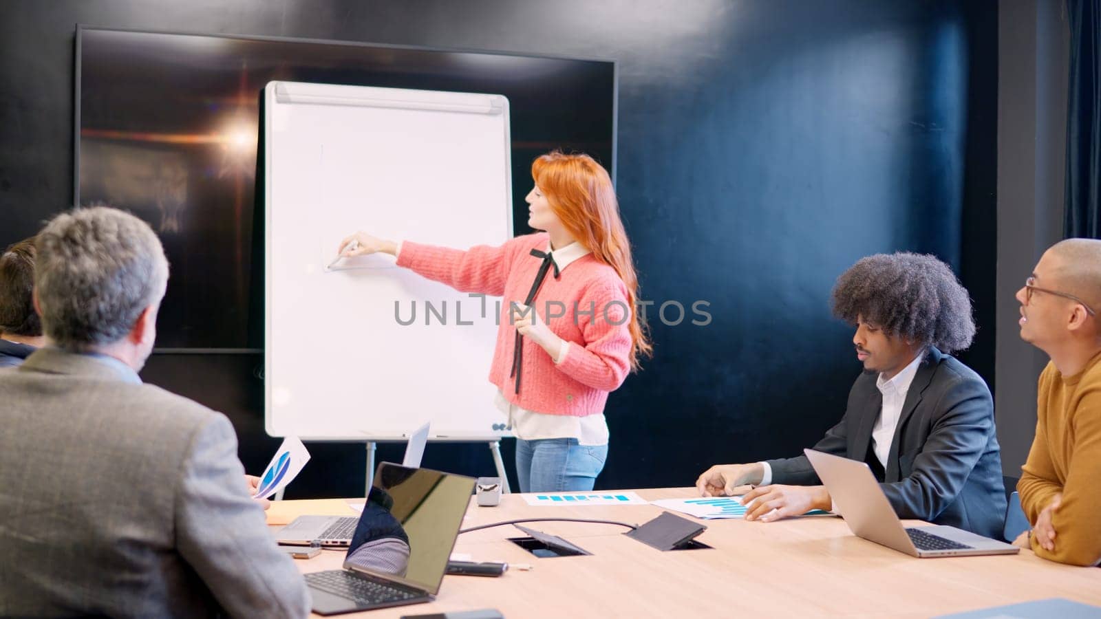 Woman using white board during a presentation of a project in a coworking space