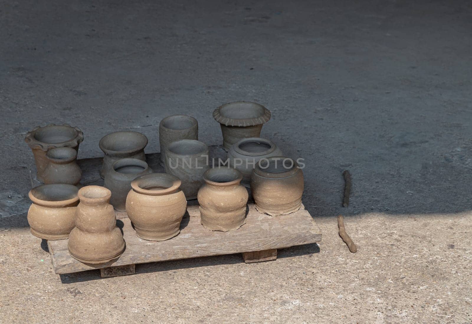 An empty of freshly made clay Pots. Clay pots background handmade art, Clay pots is drying under sun, Clay pottery, Space for text, Selective focus.