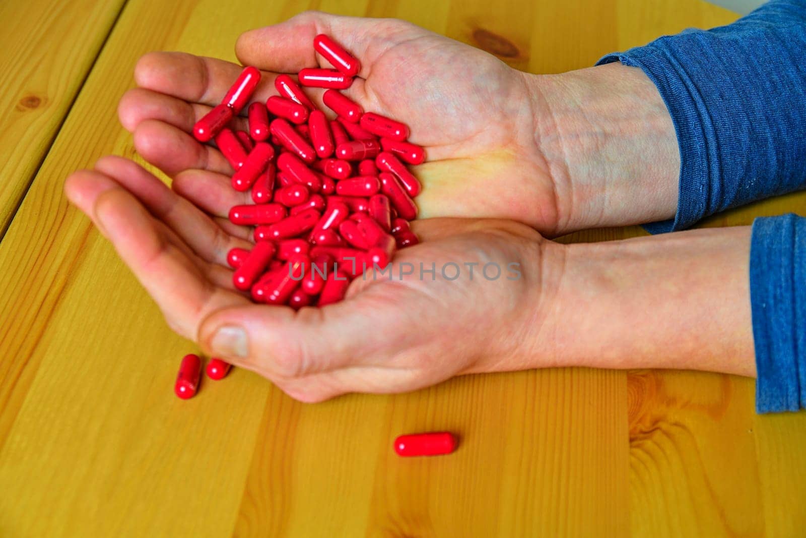 Many pills in a Senior's palms. Painful old age. Caring for the health of the elderly.