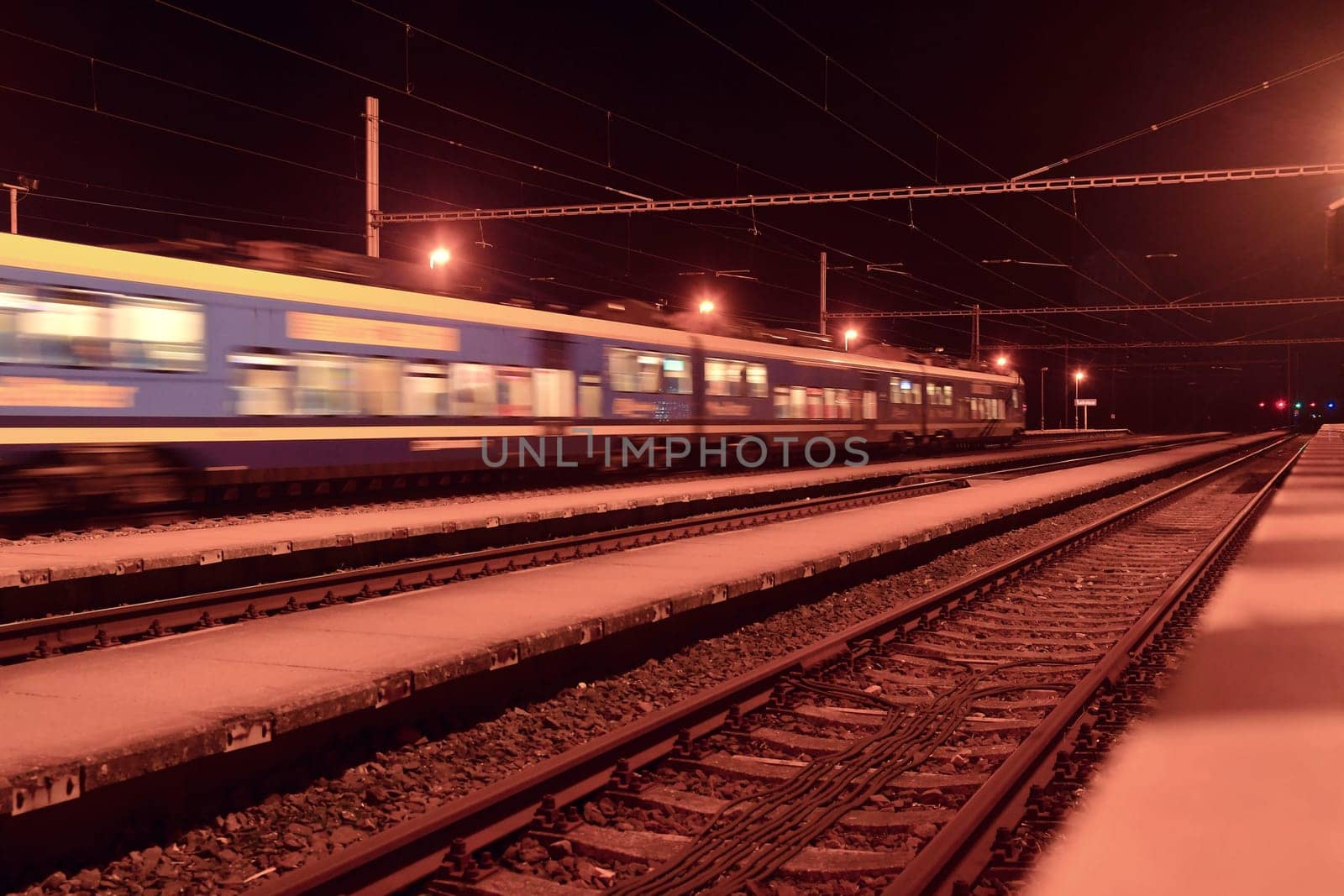 Passenger train on railroad tracks at night Blurred motion by roman_nerud