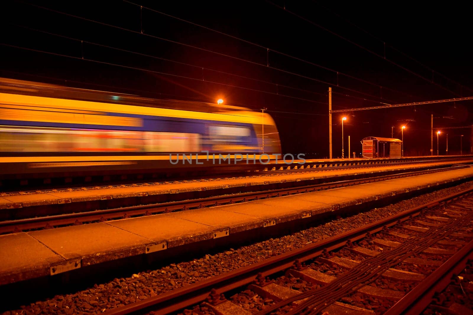 Passenger train on railroad tracks at night Blurred motion by roman_nerud