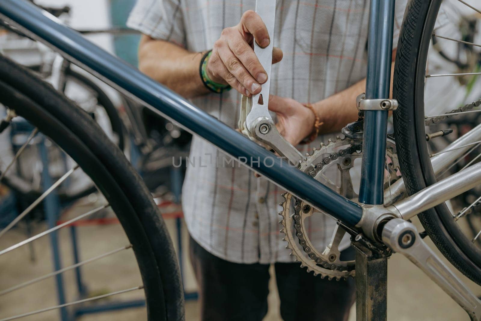 Cropped shot of male mechanic working in bicycle workshop. Bike service, repair and upgrade by Yaroslav_astakhov