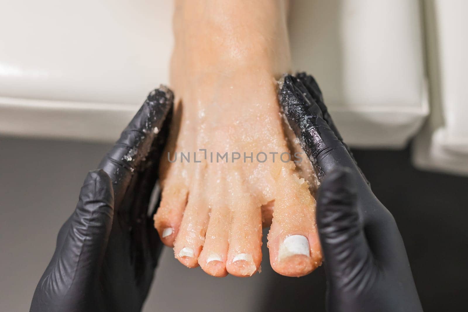 Peeling feet pedicure procedure in a beauty salon. Sugar scrub and relax beauty procedure by Satura86