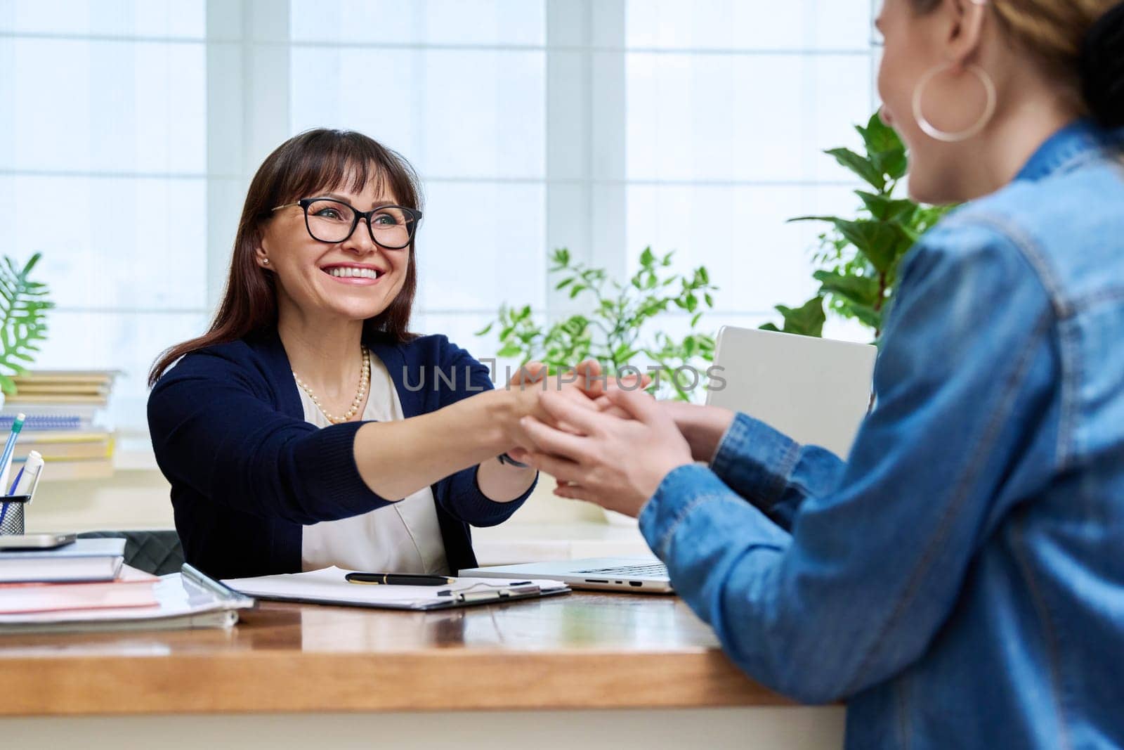 Female psychologist therapist working with young teen girl sitting in office. Teenage female student at therapy meeting with counselor. Psychology therapy psychotherapy youth mental health treatment