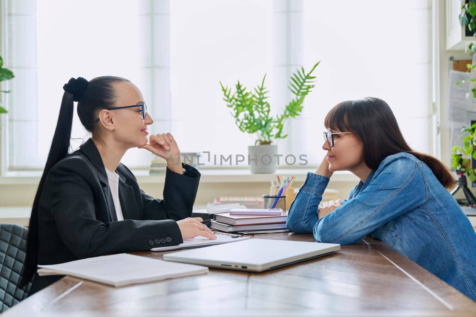 Mental therapy session of positive smiling middle-aged female patient with psychological counselor social worker psychotherapist. Psychology psychotherapy counseling, social service support treatment