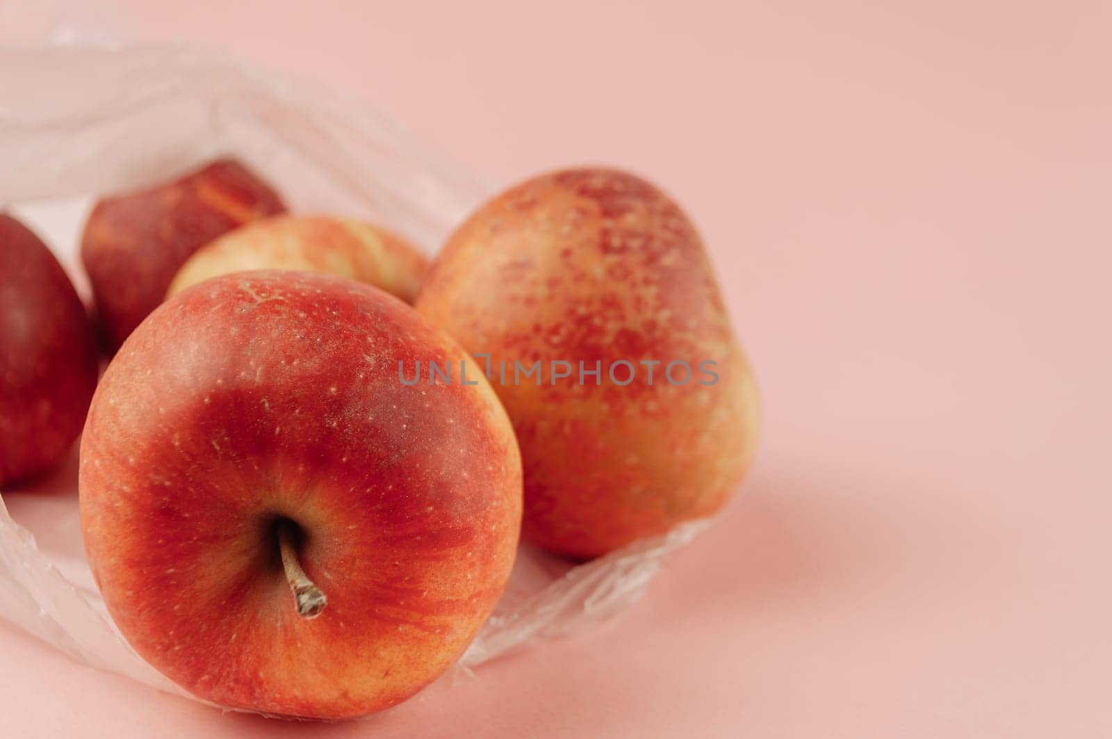 A bag of apples sits on a pink background by Alla_Morozova93
