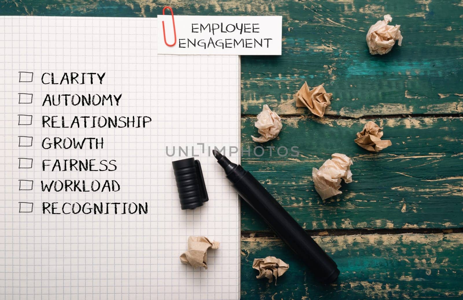 A piece of paper with a list of words and a black marker on it. The words are related to employee engagement