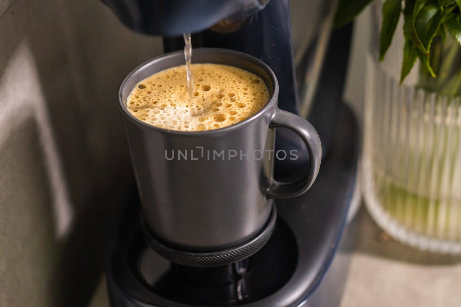 Close-up of espresso pouring from coffee machine. Professional coffee brewing.