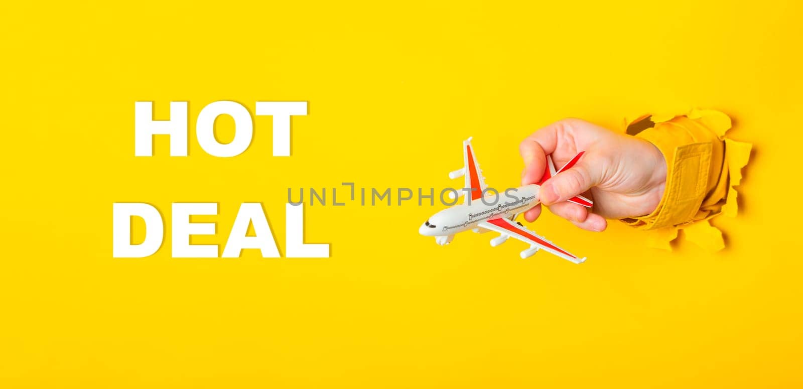 A hand holding a toy airplane with the words Hot Deal written underneath. The image has a playful and lighthearted mood, suggesting that the toy airplane is on sale for a good price