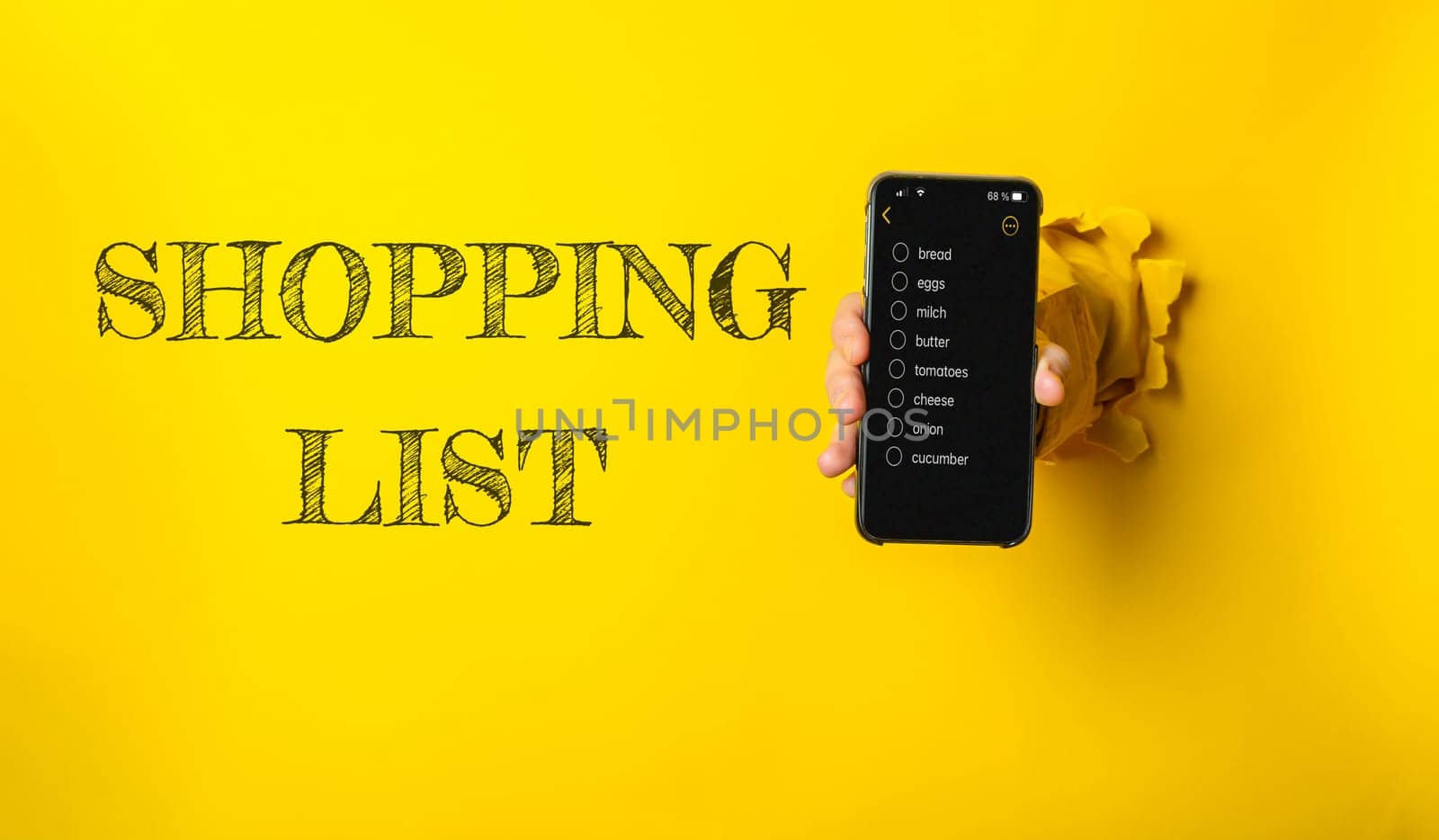 A person holds a cell phone displaying a shopping list, reflecting modern convenience and digital organization for everyday tasks like grocery shopping.