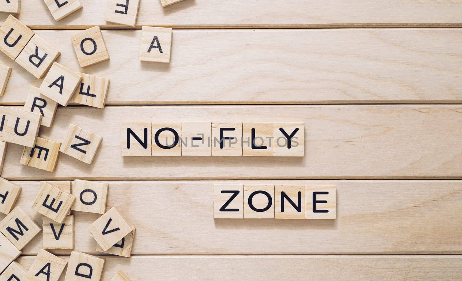 A wooden board with a jumble of letters and the words no fly zone written in the middle