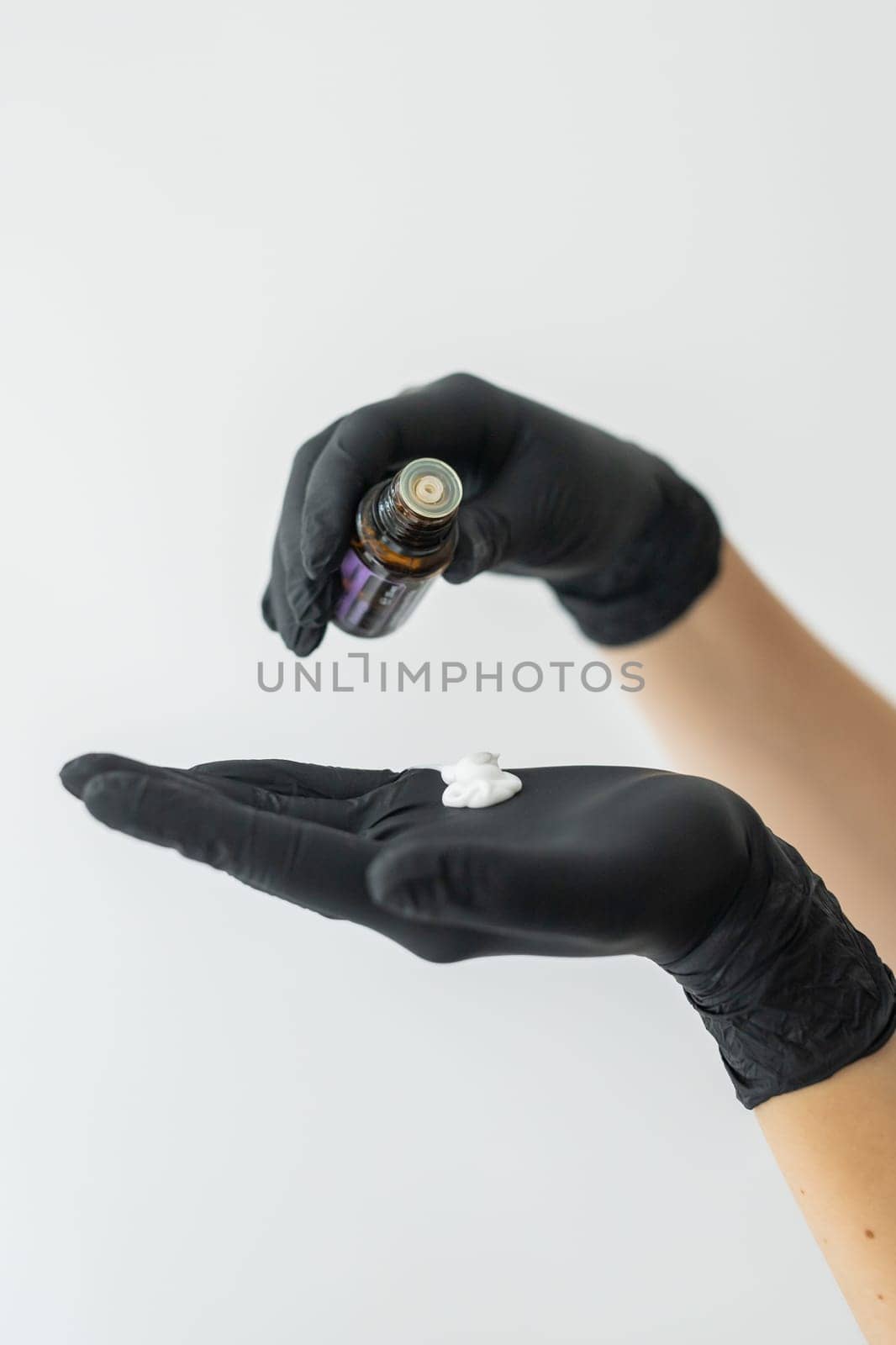 Hand cream and aroma oil for hands close-up on white wall. Wellness and spa cream hands