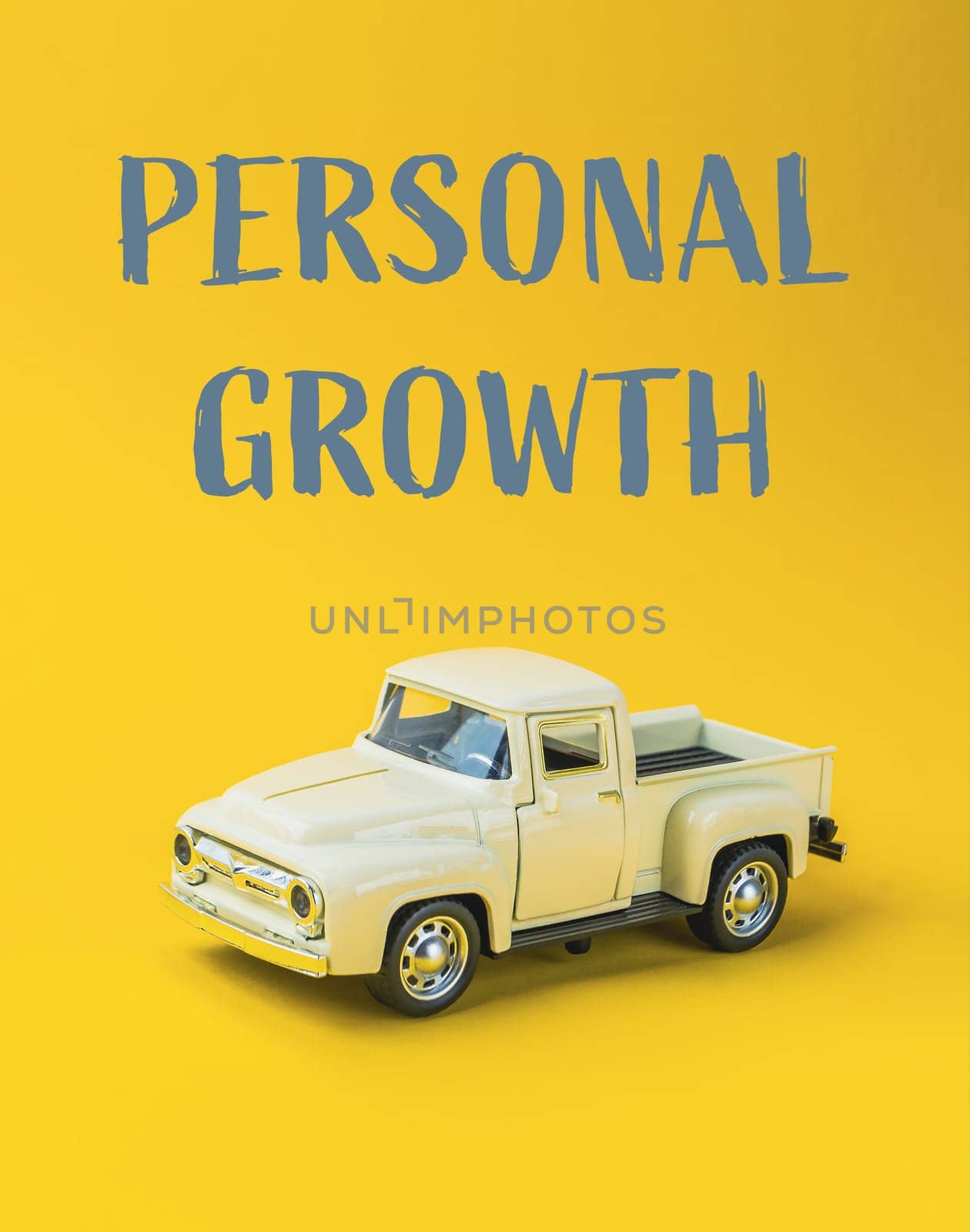 A toy truck is on a yellow background with the words Personal Growth written below it. Concept of personal growth and development, as the toy truck represents a journey or progress towards a goal