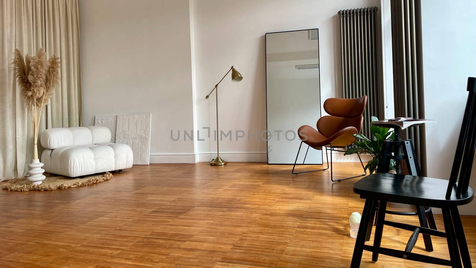 Part of the interior of the room with a soft, wooden and leather armchair, a large mirror. High quality photo