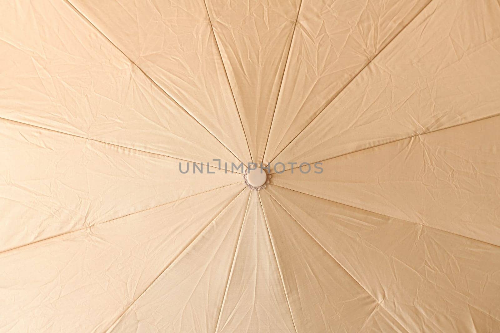 Background from open beige umbrella